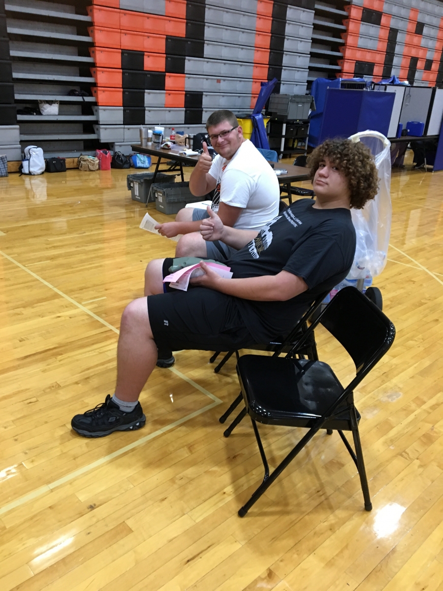 two boys in chairs with thumbs up